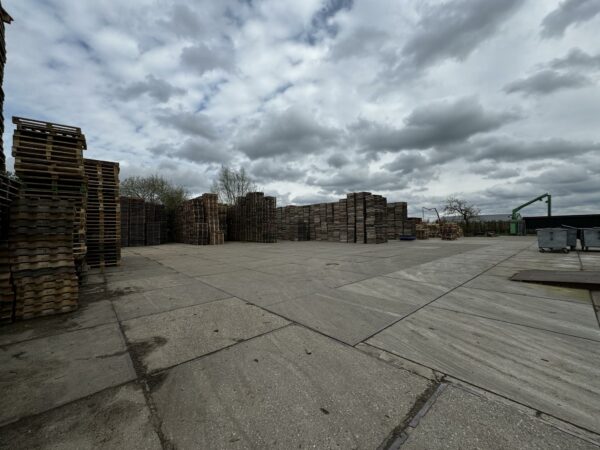 Grote voorraad houten pallets op een open opslagterrein aan de Graaf van Lynden van Sandenburgweg.